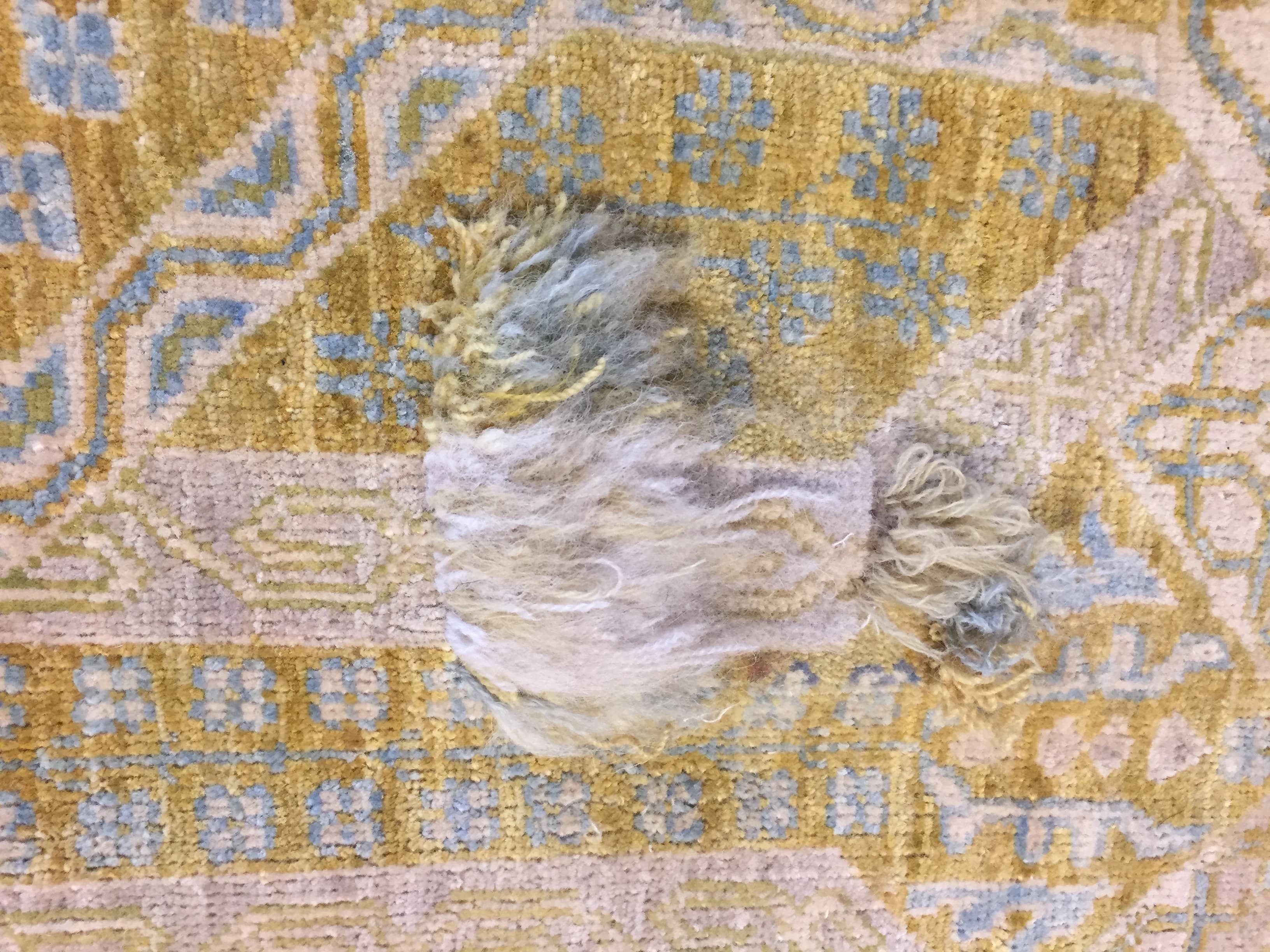 Oushak rug with an open hole exposing the foundation before reweaving — Ahmadi Rug, Gold Coast Chicago