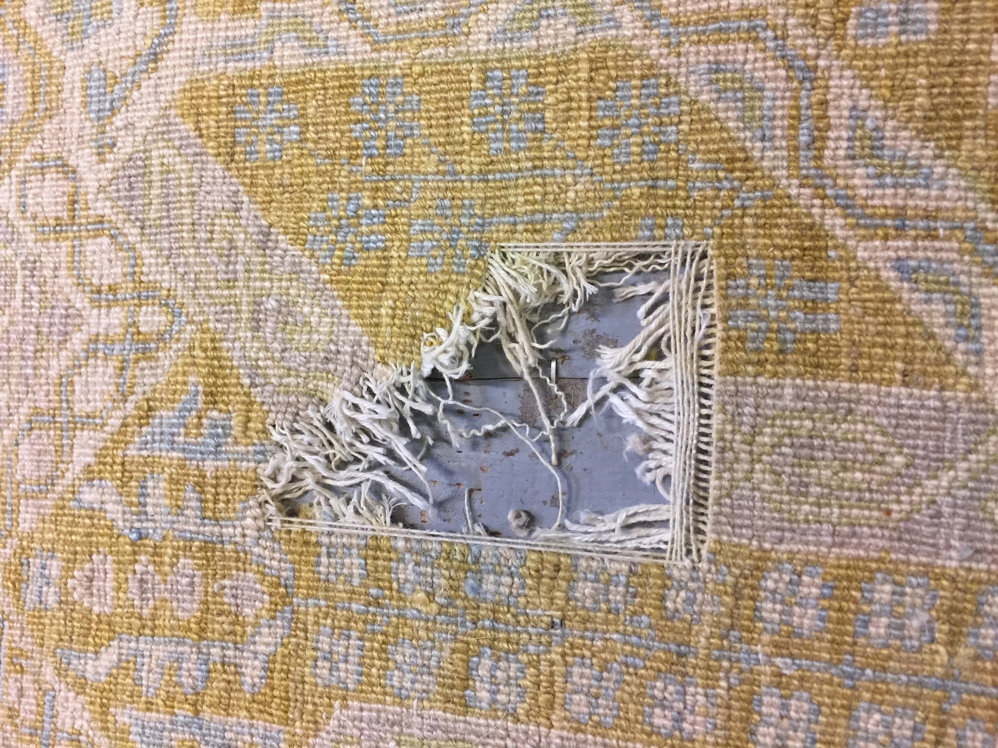 Hand reweaving an open hole in an Oushak rug, rebuilding warp, weft, and pile — Ahmadi Rug, Chicago