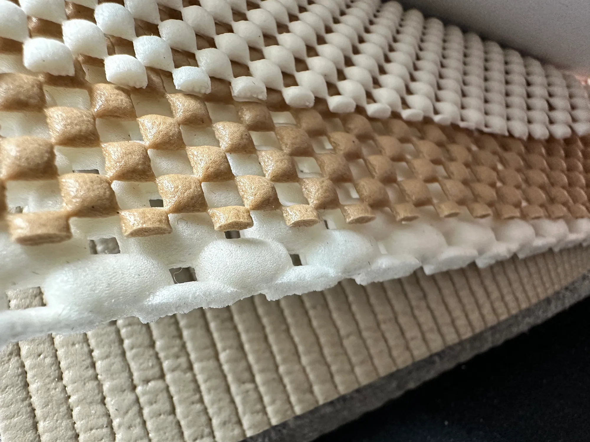 Close-up of a premium non-slip rug pad's waffle and felt construction — Ahmadi Rug, Chicago