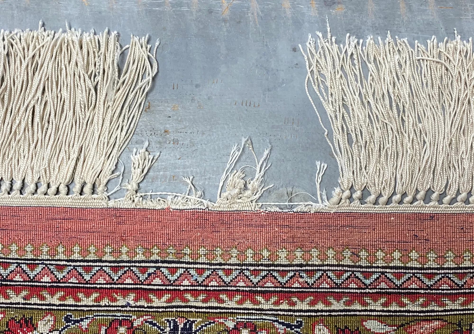 Fine silk floral rug with worn, broken fringe before restoration — Ahmadi Rug, Skokie IL