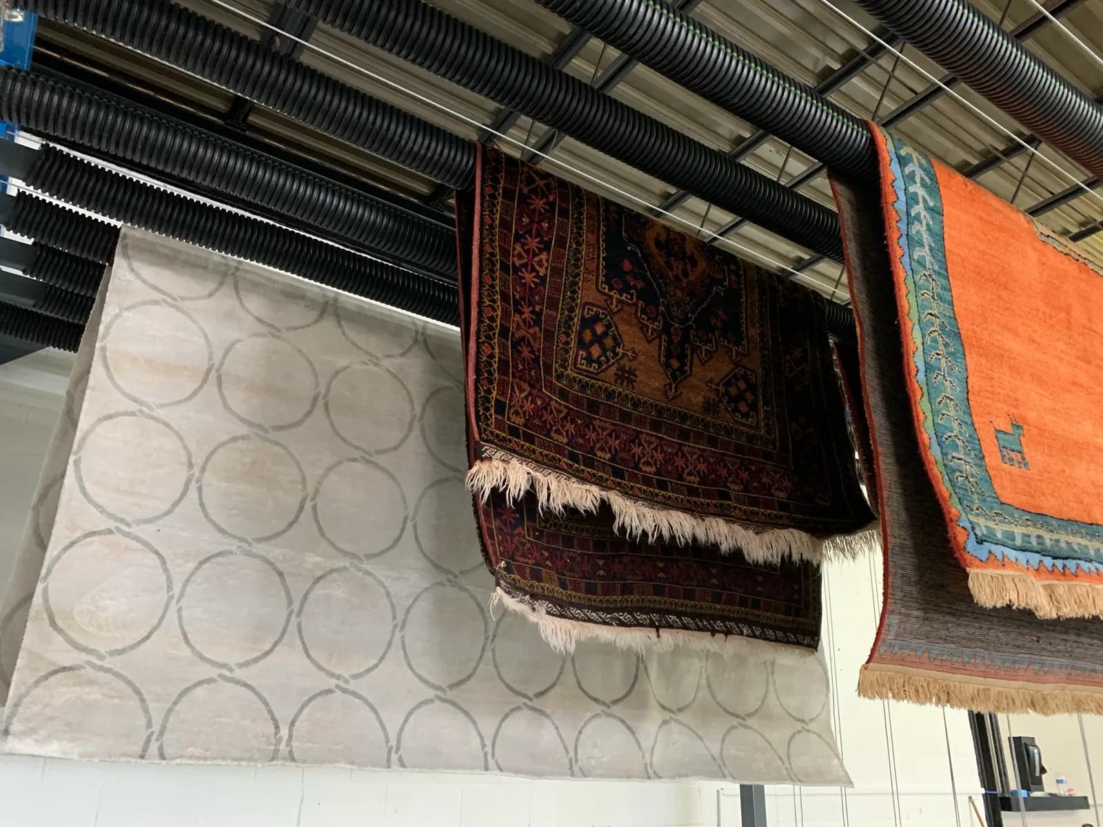 Hand-washed rugs drying flat on racks under controlled airflow — Ahmadi Rug workshop, Skokie IL